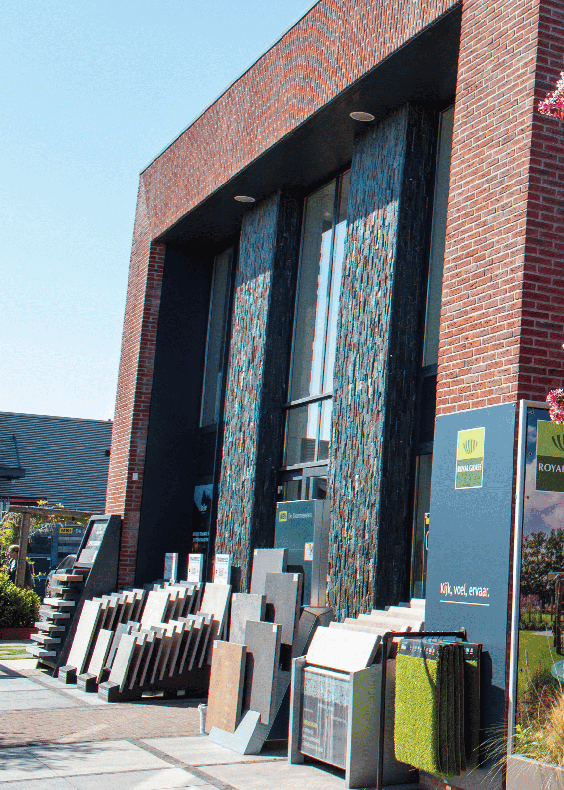 Medewerker van D'ouwe Steen in de showroom met keramische tegels en natuursteen voor tuin en terras.