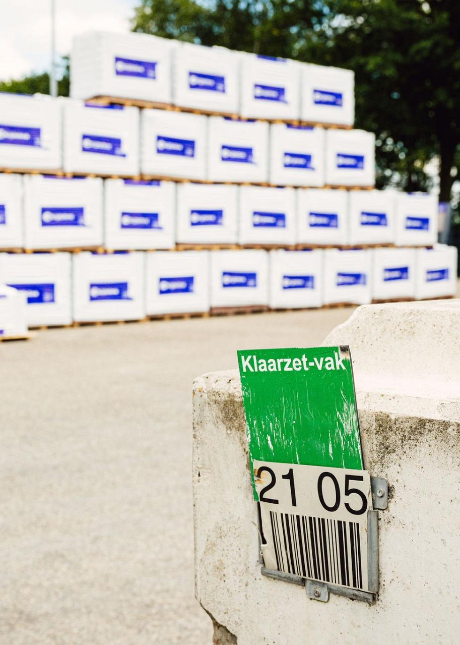 Barcode van klaarzet-vak met op de achtergrond een stapel van pallets omwikkeld in plastic.