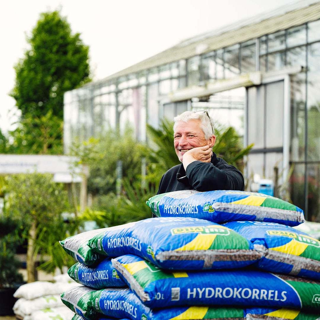 Een man die met zijn arm leunt op een stapel van hydrokorrels.
