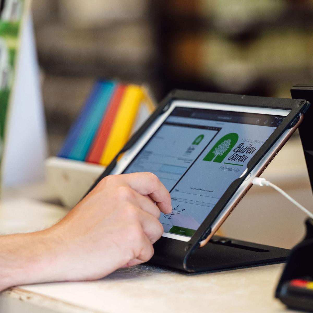 Klant ondertekent digitaal een document van Nieuwenhuis Buitenleven op een tablet