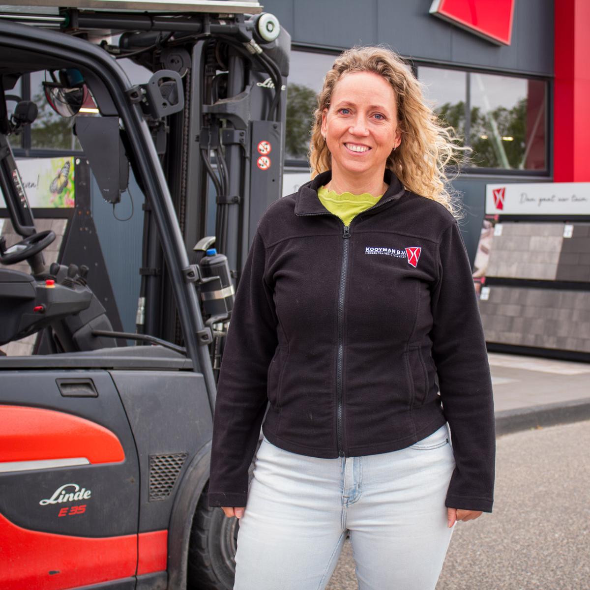 Medewerker van Kooyman B.V. naast een heftruck voor het bedrijfspand