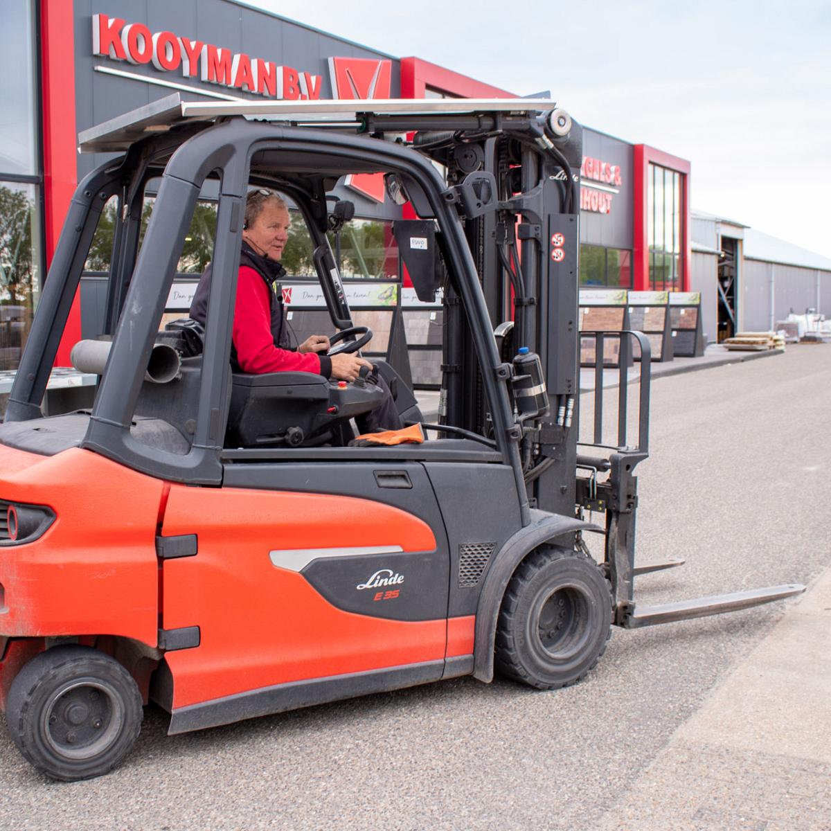 Medewerker van Kooyman B.V. op een heftruck voor de winkel en buitenpresentatie