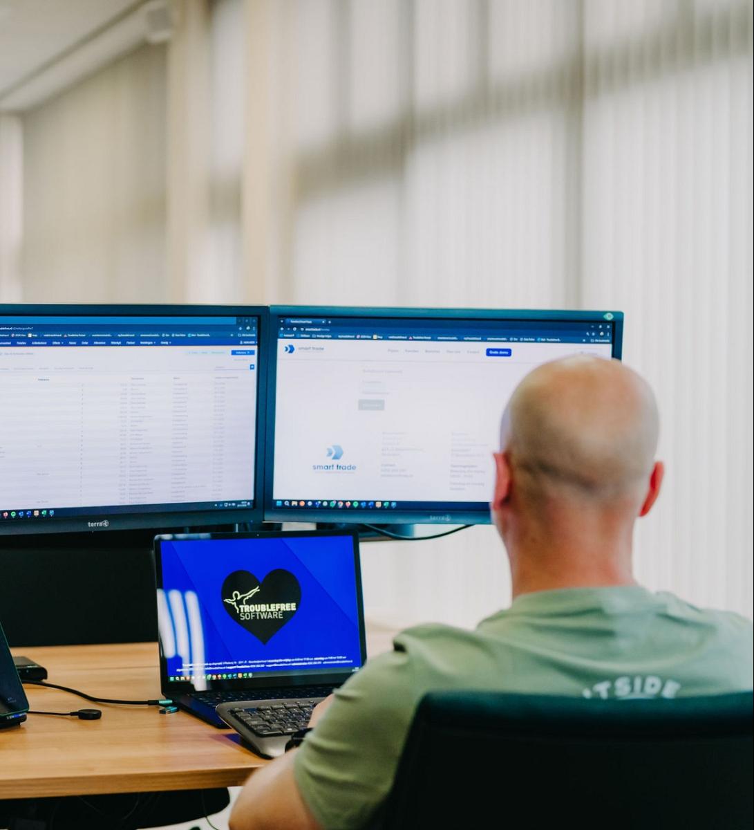 Man met een laptop in zijn hand.