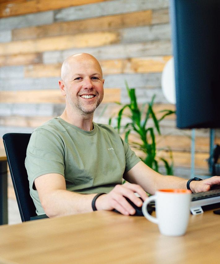 Medewerker van Smart Trade aan een bureau met een koffiekopje.