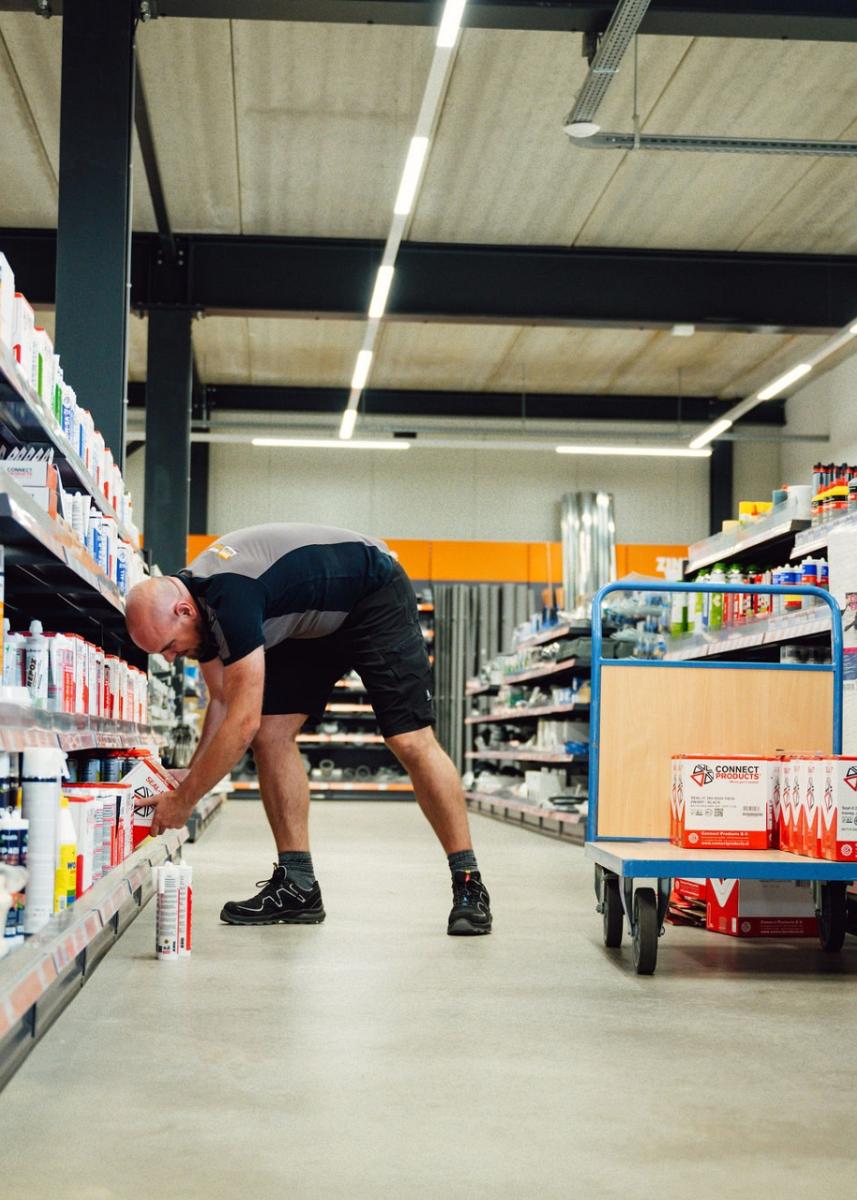 Man die iets uit winkelschap pakt.