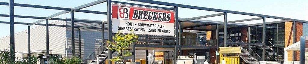 Voorkant van pand Breukers Bouwmaterialen met op de voorgrond een plateau met daarop een vierkanten fontein 